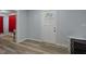A room with red curtains, modern flooring, white door and white dresser at 19496 Wildwood Dr, Brooksville, FL 34601