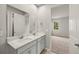 Bathroom showcasing a double sink vanity with modern fixtures, and a view into the bedroom area at 20423 Symphony Pl, Venice, FL 34293