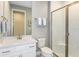Well-lit bathroom features a large glass shower, single sink, white cabinets, and neutral walls at 20423 Symphony Pl, Venice, FL 34293