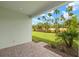 Back patio featuring a brick floor and beautiful backyard views of the lawn and palm trees at 20423 Symphony Pl, Venice, FL 34293