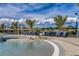 Community pool and sun loungers near a lake with palm trees at 20423 Symphony Pl, Venice, FL 34293