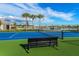 Community tennis court featuring blue and green playing surfaces, with a view of the lake at 20423 Symphony Pl, Venice, FL 34293