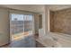 Bathroom featuring a tiled shower, white vanity, and sliding glass door to the yard at 2105 Sugarbush Dr, Holiday, FL 34690