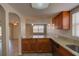 Modern kitchen with granite countertops, wood cabinetry, and stainless steel appliances at 2105 Sugarbush Dr, Holiday, FL 34690