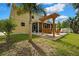 Spacious backyard featuring a screened lanai, pergola swing, and lush landscaping at 2387 Bartolo Dr, Land O Lakes, FL 34639