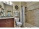 Well-lit bathroom featuring a single sink vanity, toilet, and tiled shower with neutral color palette at 2387 Bartolo Dr, Land O Lakes, FL 34639