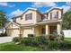 Charming two-story home with red shutters, a well-manicured lawn and a three car garage at 2387 Bartolo Dr, Land O Lakes, FL 34639