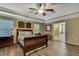 Bright main bedroom featuring a wooden bed frame, wood floors, and an entrance to an ensuite bathroom at 2387 Bartolo Dr, Land O Lakes, FL 34639