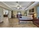 A spacious primary bedroom featuring wood floors, a ceiling fan, and an open entryway to the Gathering room at 2387 Bartolo Dr, Land O Lakes, FL 34639