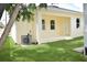A covered back porch of a cream-colored house overlooking a bright green lawn and air conditioning unit at 2504 E 28Th Ave, Tampa, FL 33605