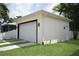 A detached garage featuring a large door, exterior lighting, and minimalist landscaping at 2504 E 28Th Ave, Tampa, FL 33605
