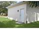 A white exterior side door on a bright white house, surrounded by a green lawn at 2504 E 28Th Ave, Tampa, FL 33605
