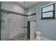 Tiled shower with glass enclosure, pebble floor, and integrated seat at 2550 Rolling View Dr, Dunedin, FL 34698