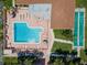An aerial view showcasing a community pool with lounge areas and shuffleboard courts at 2640 Woodgate Ln # F6, Sarasota, FL 34231