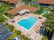 Aerial view featuring a community pool with lounge areas, landscaping, and neighborhood parking at 2640 Woodgate Ln # F6, Sarasota, FL 34231