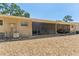 Home exterior with a screened patio, gravel ground cover, and a visible air conditioning unit at 2640 Woodgate Ln # F6, Sarasota, FL 34231
