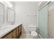 Bathroom featuring a double sink vanity, a toilet, and a glass-enclosed shower, enhanced by neutral walls at 2640 Woodgate Ln # F6, Sarasota, FL 34231