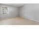 A cozy bedroom featuring neutral walls and tile flooring, complemented by a window for natural light at 2640 Woodgate Ln # F6, Sarasota, FL 34231