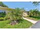 Attractive single-story home with manicured lawn, concrete walkway, and tropical palm trees at 2640 Woodgate Ln # F6, Sarasota, FL 34231