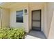 Close-up of a charming home entrance featuring a screen door, window, and lush greenery at 2640 Woodgate Ln # F6, Sarasota, FL 34231