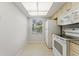 Bright kitchen featuring white appliances, granite countertops, light tile flooring, and natural light at 2640 Woodgate Ln # F6, Sarasota, FL 34231