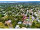 An aerial view of a beautiful home with a pool in a tranquil, tree-lined neighborhood, with a distant bay view at 2662 Oakbrook Dr, Largo, FL 33770