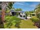 Spacious backyard featuring a patio seating area, green lawn, and a glimpse of the swimming pool at 2662 Oakbrook Dr, Largo, FL 33770