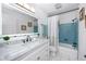 Modern bathroom with a white vanity, a large mirror, and a tub with a shower at 2662 Oakbrook Dr, Largo, FL 33770