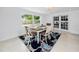 Bright dining room featuring a modern table set with seating for six and a large window overlooking the yard at 2662 Oakbrook Dr, Largo, FL 33770
