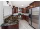 Modern kitchen with stainless steel appliances, granite counters, and wooden cabinetry at 2662 Oakbrook Dr, Largo, FL 33770