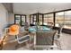 Bright sunroom with a glass table set for six, offering an inviting space for dining and relaxation at 2662 Oakbrook Dr, Largo, FL 33770