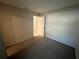 Carpeted bedroom with neutral walls and an open door offering a glimpse into an adjacent room at 2826 Rampart Cir, Clearwater, FL 33761
