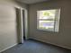 Bright bedroom featuring a large window with blinds, closet, neutral walls, and comfortable carpet at 2826 Rampart Cir, Clearwater, FL 33761