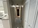Bright hallway with tile flooring leading to kitchen with white appliances and cabinets at 2826 Rampart Cir, Clearwater, FL 33761