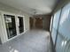 Bright sunroom with tiled floors, ceiling fan and windows with views and access to other rooms at 2826 Rampart Cir, Clearwater, FL 33761