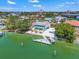 Waterfront home featuring a private dock, lush landscaping, and panoramic views of the harbor on a sunny day at 3021 Alton Dr, St Pete Beach, FL 33706