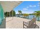 Large backyard patio overlooking the water, complete with a bench and palm trees for a relaxing view at 3021 Alton Dr, St Pete Beach, FL 33706