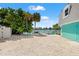 Inviting backyard with sandy area, lush trees, and private dock overlooking serene waterfront at 3021 Alton Dr, St Pete Beach, FL 33706