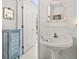 Bathroom features a pedestal sink and decorative mirror at 3021 Alton Dr, St Pete Beach, FL 33706