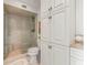 Bathroom featuring a glass shower, tile surround, and white storage cabinets at 3021 Alton Dr, St Pete Beach, FL 33706