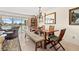 Inviting dining area featuring a wooden table, accent chairs, bench, and water views at 3021 Alton Dr, St Pete Beach, FL 33706
