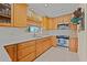 Close up of the kitchen featuring wooden cabinets, a window, stainless steel appliances, and a tiled backsplash at 3021 Alton Dr, St Pete Beach, FL 33706