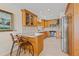 Kitchen featuring wooden cabinets, stainless steel appliances, tiled floors and a breakfast bar with seating at 3021 Alton Dr, St Pete Beach, FL 33706