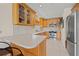 Kitchen featuring wooden cabinets, stainless steel appliances, tiled floors and a breakfast bar with seating at 3021 Alton Dr, St Pete Beach, FL 33706