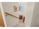 Staircase with neutral walls, carpeted steps, a wooden handrail, and decorative wall art at 3021 Alton Dr, St Pete Beach, FL 33706