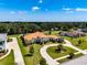Stunning aerial of a Mediterranean-style home with a terracotta roof and circular driveway surrounded by verdant landscaping at 304 Hawk Talon Dr, Lithia, FL 33547