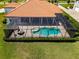 An aerial view shows the screened-in pool, lush yard, and fire pit in a backyard oasis at 304 Hawk Talon Dr, Lithia, FL 33547