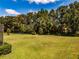A expansive green lawn, mature trees and trimmed hedges provide a serene backyard setting at 304 Hawk Talon Dr, Lithia, FL 33547
