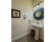 Well-lit powder room with pedestal sink, unique mirror, and decorative artwork at 304 Hawk Talon Dr, Lithia, FL 33547
