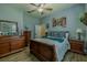Charming bedroom featuring light blue walls, ceiling fan, wood floors, and ample closet space at 304 Hawk Talon Dr, Lithia, FL 33547